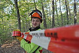 Linkziel: Link zum Beitrag mit dem Thema Medieninformation; Bildinhalt: Ein Waldarbeiter sichert einen Bereich im Wald mit Absperrband.